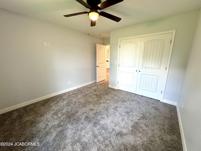 unfurnished bedroom featuring ceiling fan, a closet, and dark colored carpet