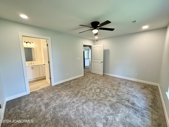 unfurnished bedroom featuring connected bathroom, light colored carpet, and ceiling fan