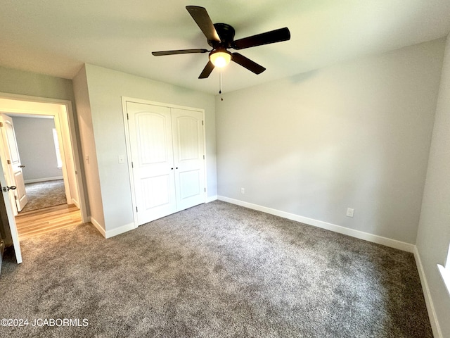 unfurnished bedroom featuring ceiling fan, a closet, and carpet