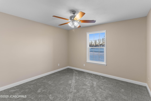spare room with dark carpet, baseboards, and a ceiling fan