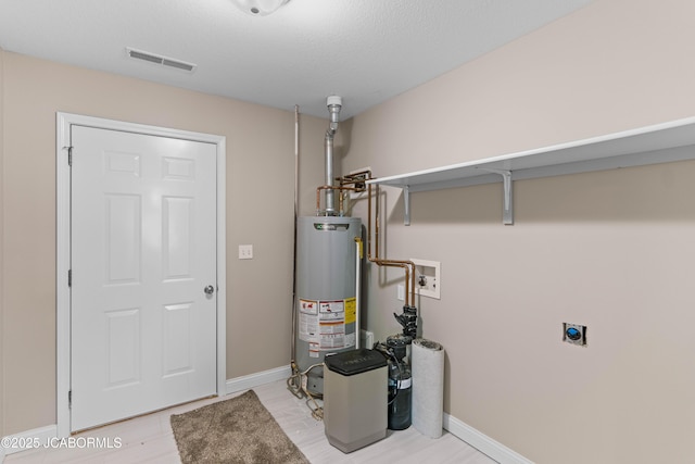 utility room with visible vents and gas water heater
