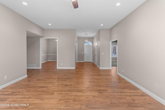 empty room featuring recessed lighting, visible vents, light wood-type flooring, and baseboards
