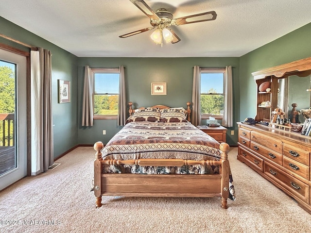 bedroom with access to outside, multiple windows, and light colored carpet