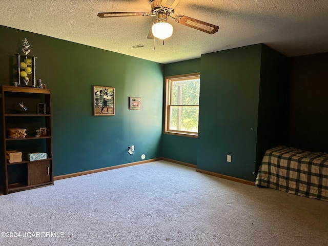 bedroom featuring a textured ceiling, ceiling fan, carpet, and baseboards