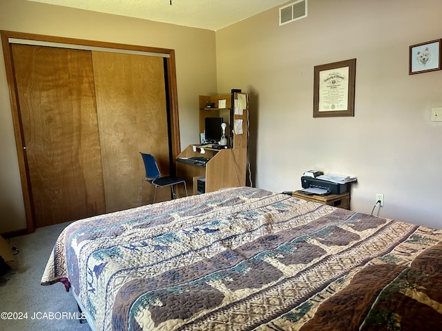 carpeted bedroom featuring a closet and visible vents