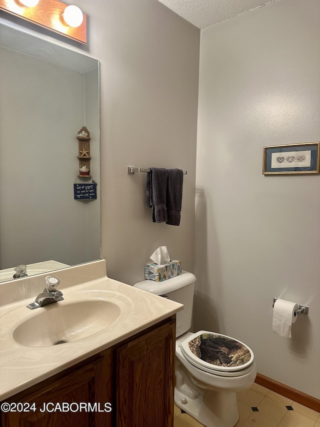 half bath with baseboards, vanity, and toilet