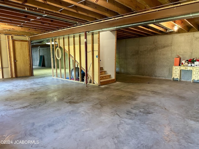 unfinished basement featuring stairs