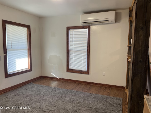 unfurnished room featuring dark hardwood / wood-style flooring and a wall mounted air conditioner