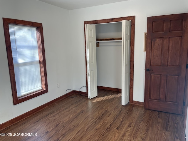 unfurnished bedroom with dark hardwood / wood-style flooring and a closet