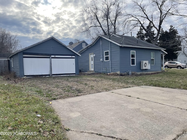 view of front of property with ac unit, a garage, and a front yard