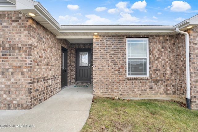 view of exterior entry with a yard