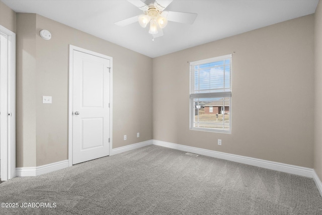 unfurnished room with ceiling fan and carpet floors