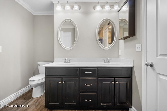 bathroom featuring vanity, hardwood / wood-style floors, ornamental molding, and toilet