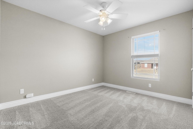 spare room with ceiling fan and carpet