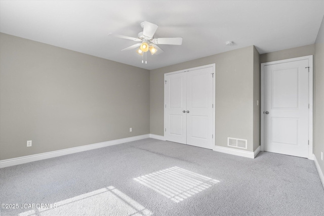 unfurnished bedroom featuring light carpet, a closet, and ceiling fan