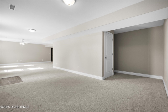 basement featuring ceiling fan and light colored carpet