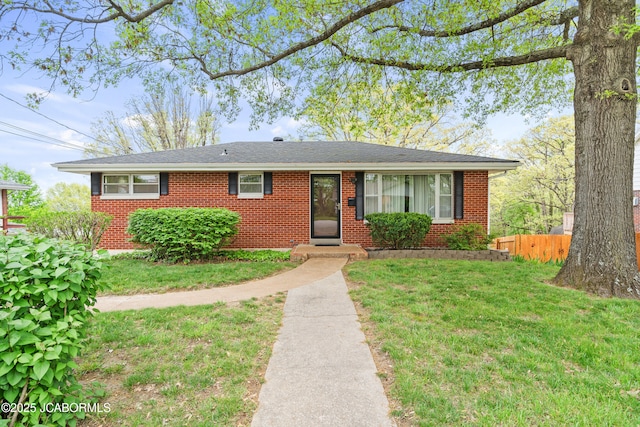 1213 Edgewood Dr, Jefferson City, MO 65109 - view of front facade featuring fence, a shingled roof, a front lawn, and brick siding
