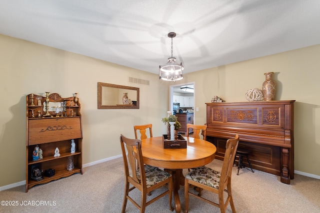 dining space featuring carpet flooring and a chandelier