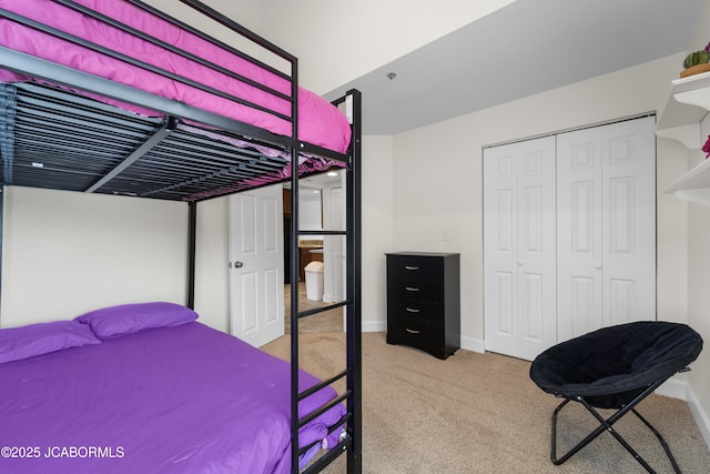 carpeted bedroom with a closet and baseboards