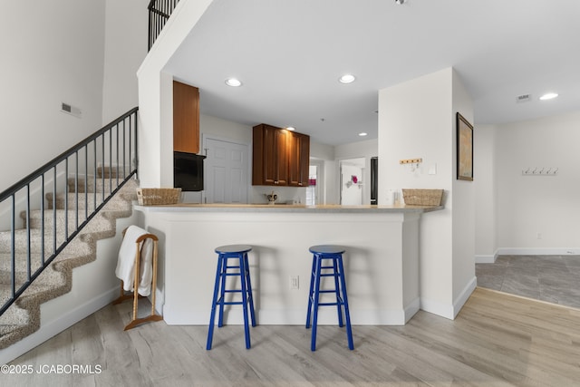 kitchen with baseboards, visible vents, and wood finished floors