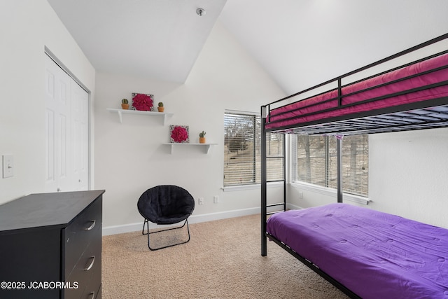 bedroom with carpet, a closet, vaulted ceiling, and baseboards