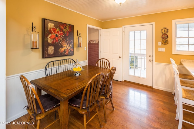 dining area with a wealth of natural light, wainscoting, and wood finished floors