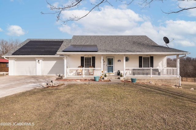 ranch-style home featuring solar panels, covered porch, a front yard, a garage, and driveway