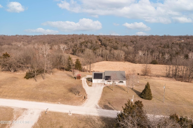 drone / aerial view featuring a rural view and a view of trees