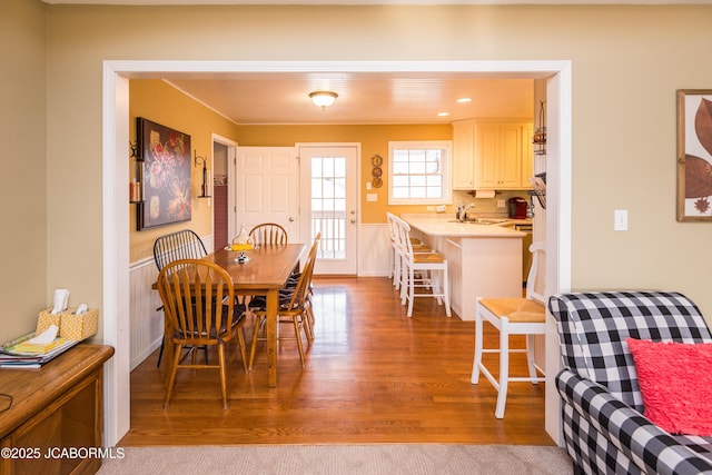 dining space with a wainscoted wall, wood finished floors, and recessed lighting