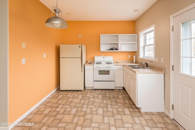 kitchen featuring white appliances, a sink, hanging light fixtures, light countertops, and open shelves