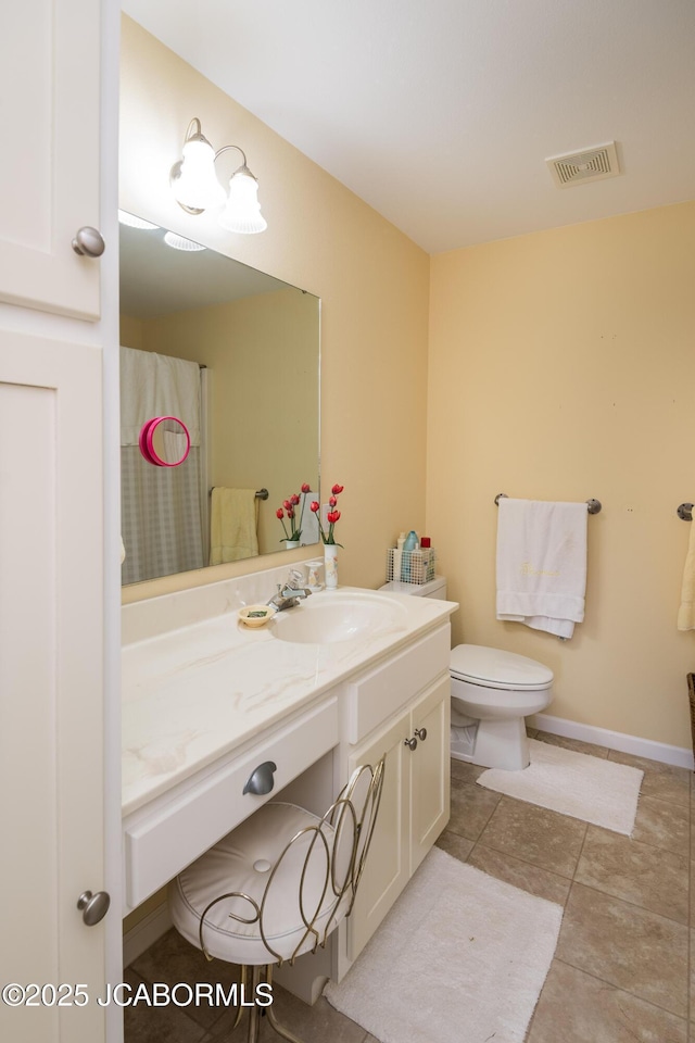 bathroom with visible vents, toilet, vanity, tile patterned flooring, and baseboards