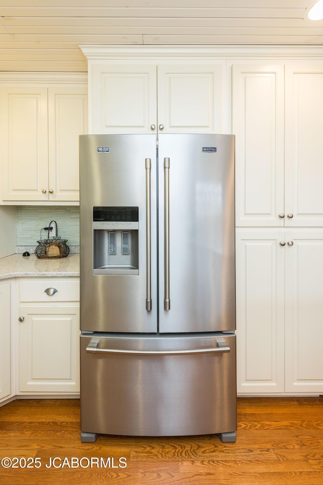 kitchen featuring white cabinets, high quality fridge, and light wood-style flooring