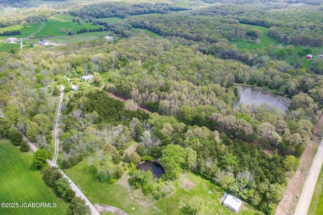 drone / aerial view featuring a water view and a forest view