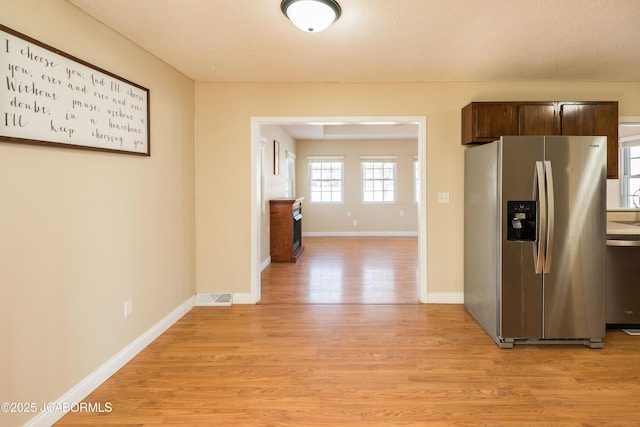 kitchen featuring light hardwood / wood-style floors, dark brown cabinets, a textured ceiling, and stainless steel appliances