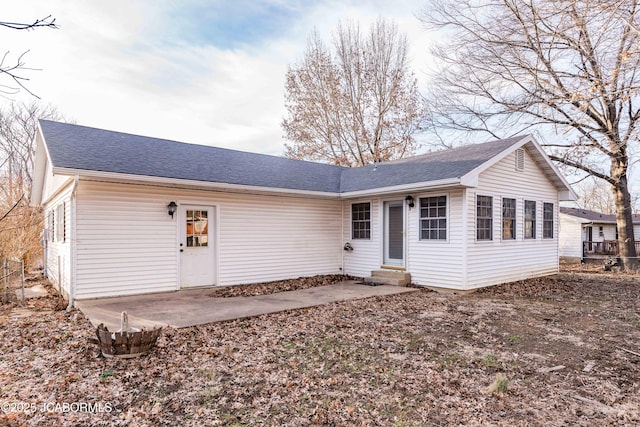 view of front of home with entry steps, a patio, and a shingled roof