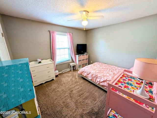 carpeted bedroom featuring ceiling fan and a textured ceiling