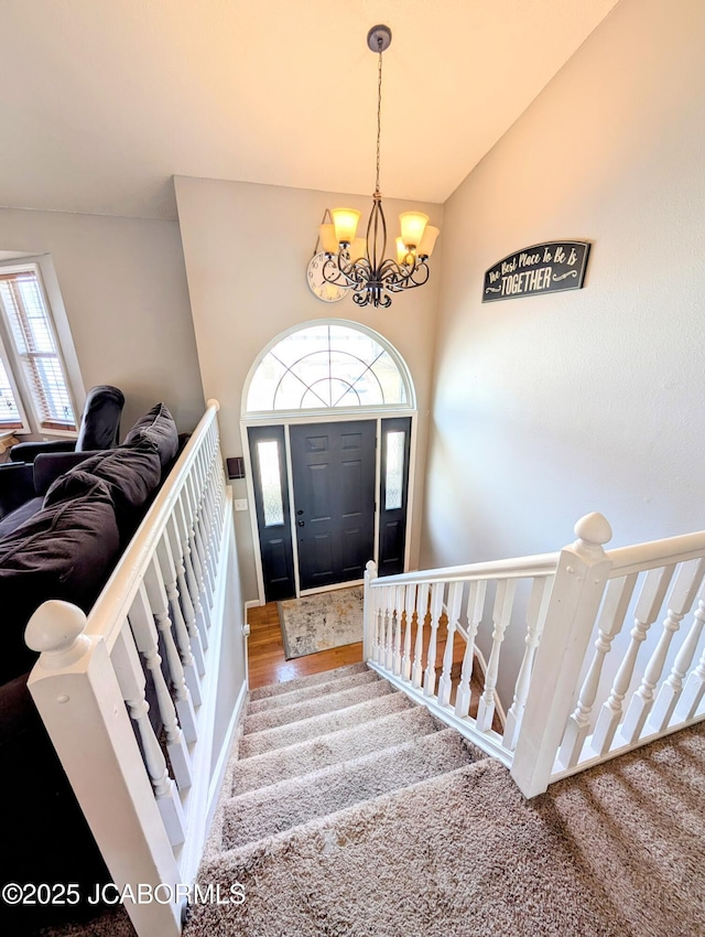 foyer entrance with vaulted ceiling, a chandelier, and a healthy amount of sunlight