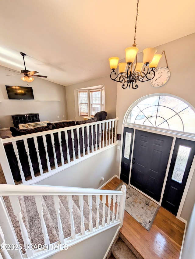 foyer entrance with hardwood / wood-style flooring, lofted ceiling, and a notable chandelier