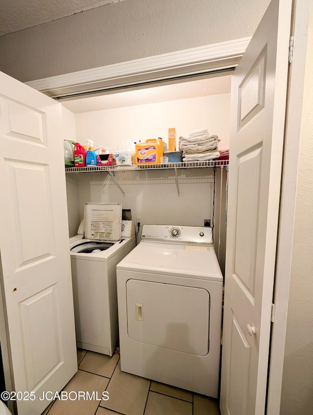 laundry room featuring light tile patterned floors and washer and clothes dryer