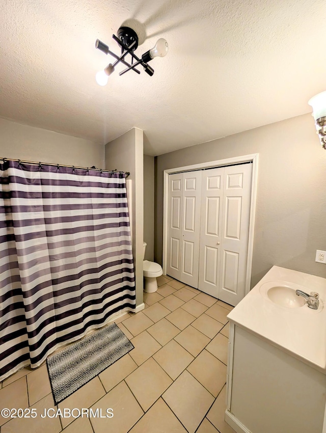 bathroom with vanity, tile patterned floors, a textured ceiling, and toilet