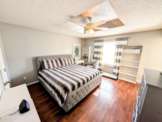 bedroom featuring ceiling fan, dark hardwood / wood-style floors, and a textured ceiling