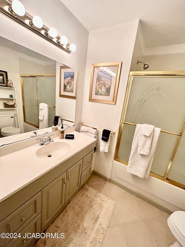 full bathroom featuring shower / bath combination with glass door, tile patterned floors, toilet, and vanity