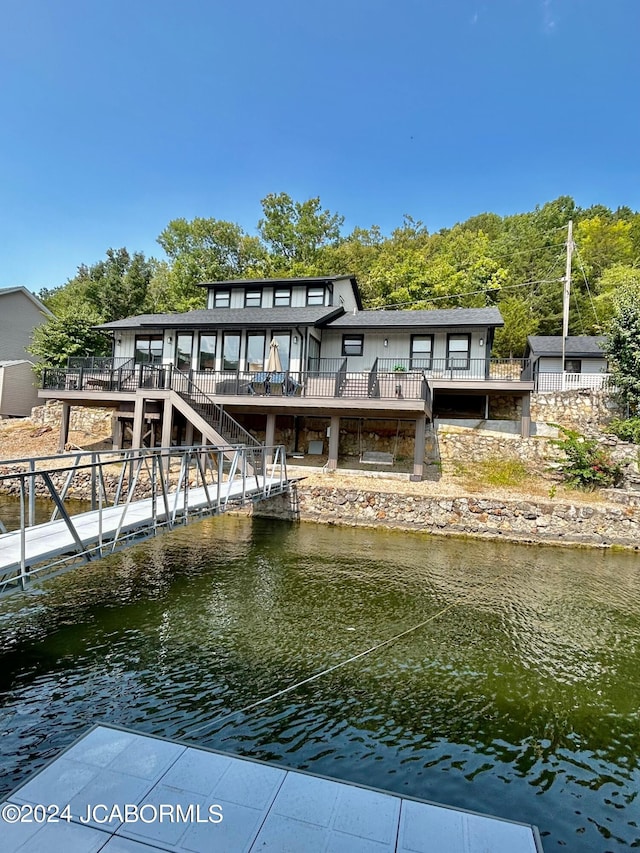 rear view of property featuring a deck with water view