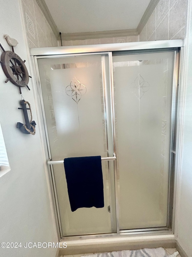 bathroom with an enclosed shower and crown molding