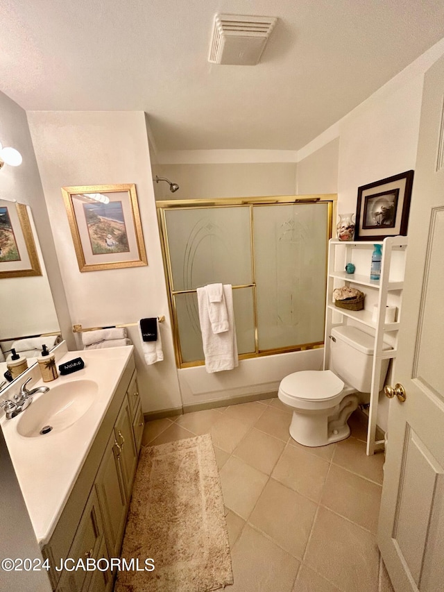 full bathroom with tile patterned flooring, enclosed tub / shower combo, vanity, and toilet