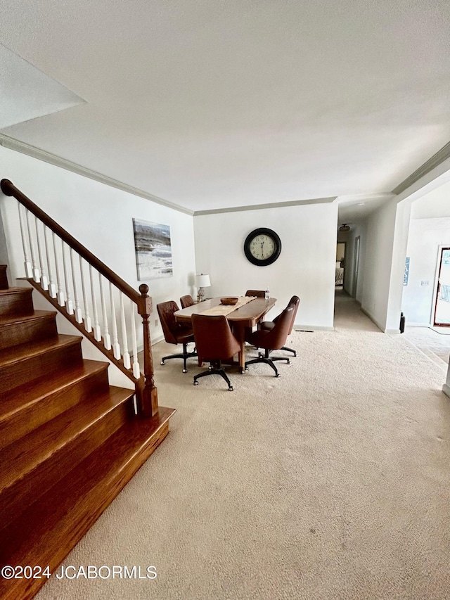 carpeted dining space featuring ornamental molding