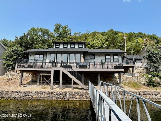 back of property featuring a deck with water view