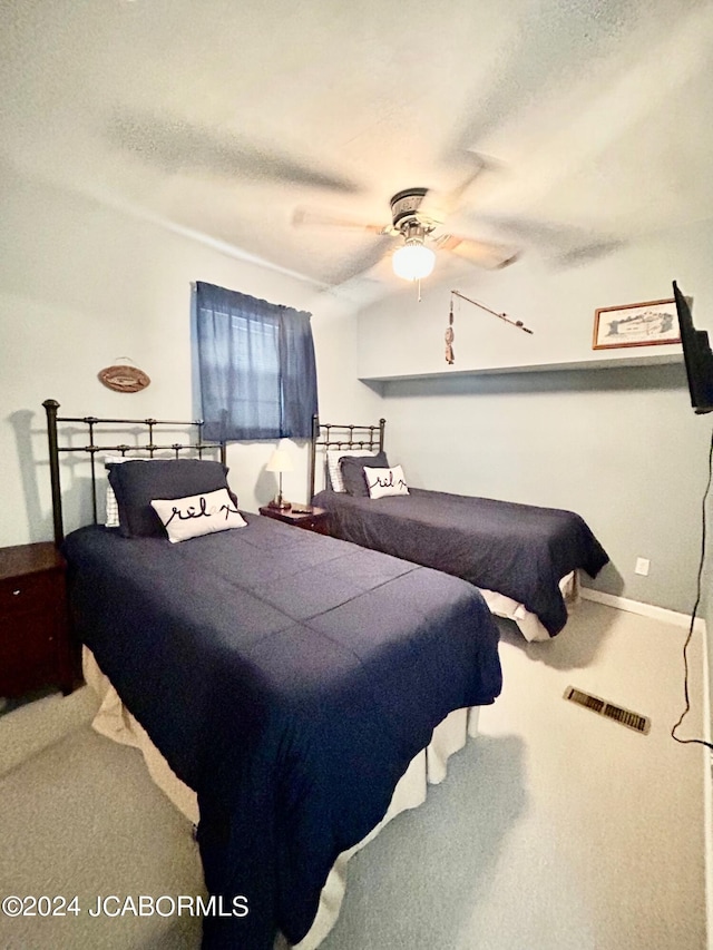 carpeted bedroom featuring a textured ceiling and ceiling fan