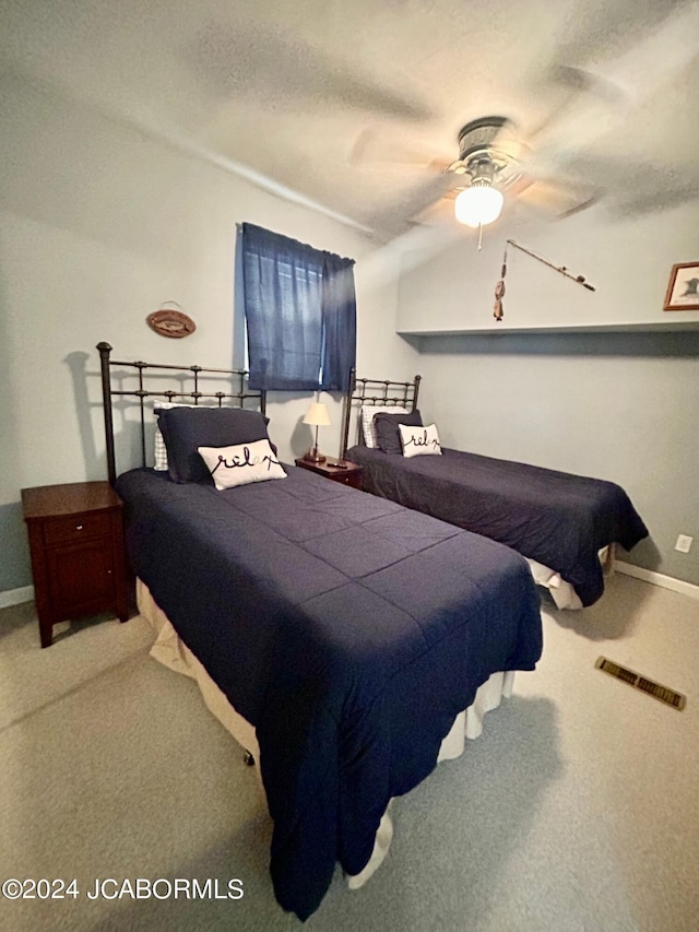 carpeted bedroom with ceiling fan and a textured ceiling