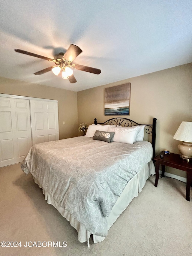 carpeted bedroom with ceiling fan and a closet